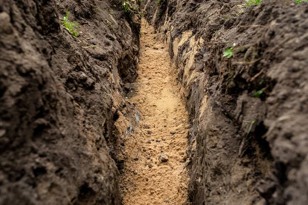 一道壕沟沿着栅栏在院子里挖来的壕沟 用来铺设明显的黄沙排水管 — 图库照片