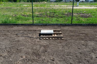 Bahçedeki Chernozem 'i beton küple ağırlıklı bir paletle düzleştirmek, çimenlik ekmeye hazırlanmak..