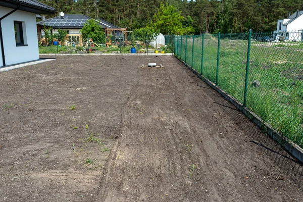 庭のケルノゼムをコンクリートの立方体で重さのあるパレットでレベリングし 芝生を播種する準備をする — ストック写真