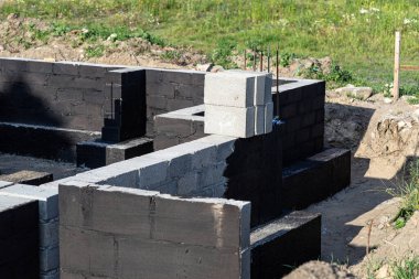 Siyah dağılım asfalt kauçuk kütle ile boyanmış beton bloklardan yapılmış tabanlar görünür beton sütunlar..