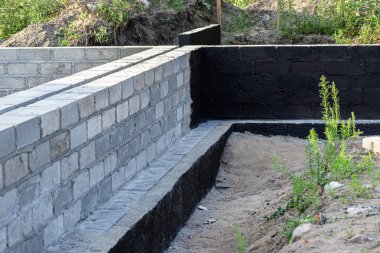 Siyah dağılım asfalt kauçuk kütle ile boyanmış beton bloklardan yapılmış tabanlar görünür beton sütunlar..