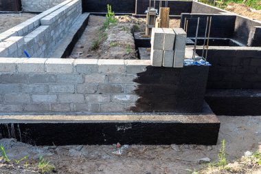 Siyah dağılım asfalt kauçuk kütle ile boyanmış beton bloklardan yapılmış tabanlar görünür beton sütunlar..