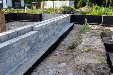Siyah dağılım asfalt kauçuk kütle ile boyanmış beton bloklardan yapılmış tabanlar görünür beton sütunlar..