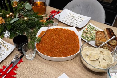 Masa, Polonya 'daki Noel yemeğinden önce havuç salatası, köfte ve kroket içinde fırında balık filetosu ile hazırlandı..