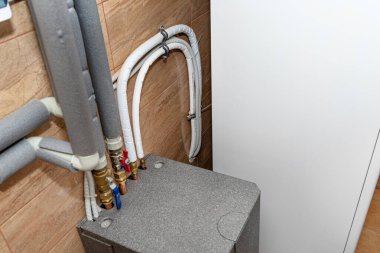 Evin kazan dairesine modern bir hava pompası kurulmuş, görünür bir ısı değiştirici..