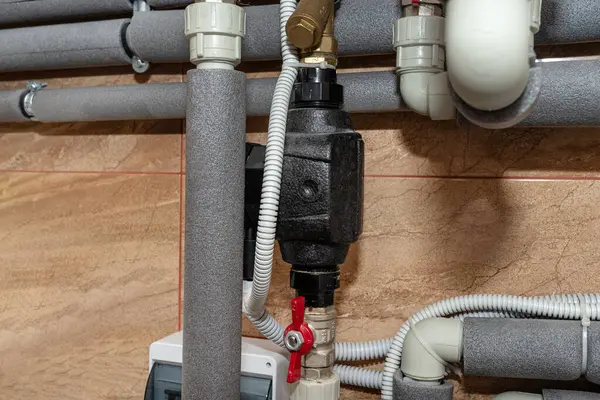 Circulation pump for domestic water installed in a modern heat pump installation in the boiler room.