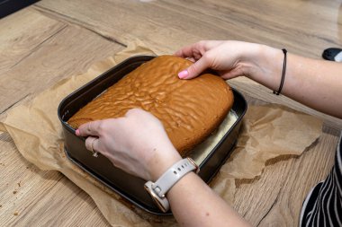 Polonya pastası hazırlama, kremalı şekerleme, kadın bir kat pasta koyar.