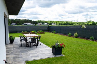 Çiğ ahşaptan yapılmış, bahçe terasında duran vernikle kaplı modern bir masa..