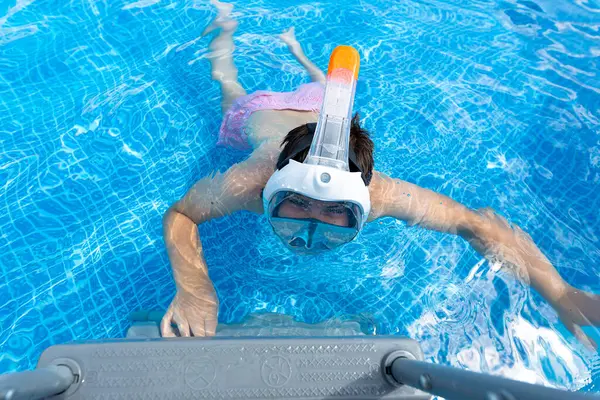 stock image A smiling ten-year-old boy in a backyard swimming pool with a snorkeling mask