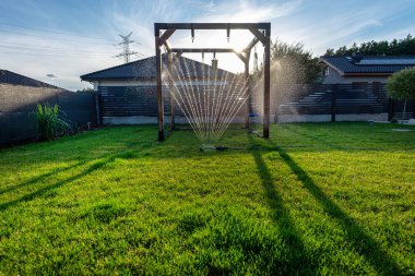 Çimen salıncakları evin arka bahçesindeki çimleri suluyor..