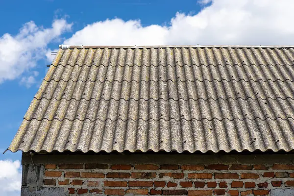 stock image An old brick barn in the Polish countryside with a corrugated asbestos roof.