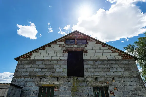 stock image An old brick barn in the Polish countryside with a corrugated asbestos roof.