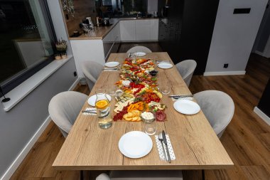 Çeşitli peynirler ve salamlar masanın üzerine yayılmış, evde akşam partisi..