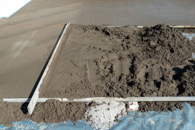 Takviyeyle kaplı bir terasa el yapımı beton dökülüyor..