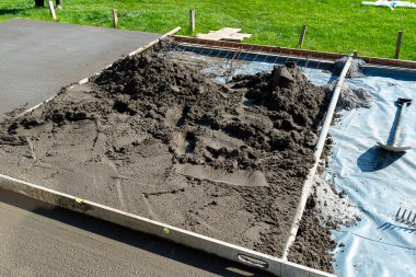 Takviyeyle kaplı bir terasa el yapımı beton dökülüyor..