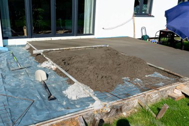 Takviyeyle kaplı bir terasa el yapımı beton dökülüyor..