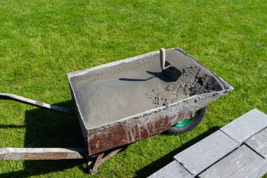 Serbest beton karıştırıcıya elle karıştırılmış sıvı betonla dolu bir el arabası..