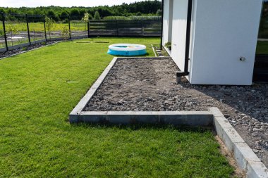 Benzin destekli sıkıştırıcı kullanarak inşaat halindeki bir terasta moloz sıkıştırmak.