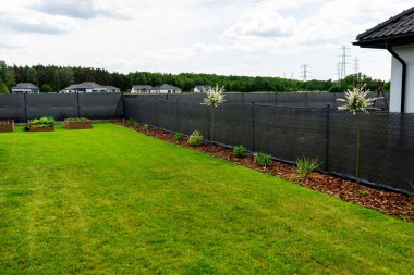 Çit boyunca çam ağacının kabuğunda yetişen süslü bitkiler..