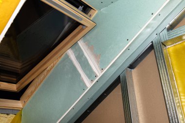 Çatı penceresi mavi alçıyla kaplı, görünür buharla geçirgen folyo.