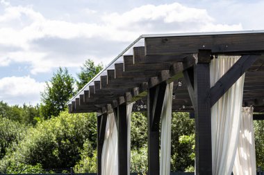 Evin arkasındaki terasın görünür kiriş bağlantıları var. Çatı polikarbonatla kaplı..
