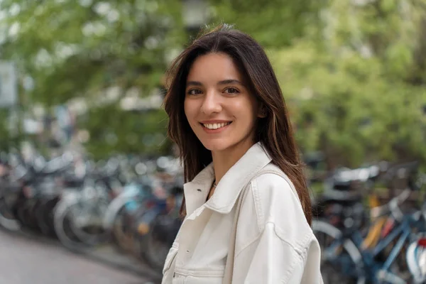 stock image Portrait of Turkish splendid looking young woman confident about bright future on urban street with bicycles in the background.