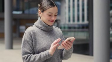 Amaçla yürüyor, kolaylıkla kayıyor. Günlük giysili bir kadın cam kaplı caddelerde, elinde telefonla, dijital dünyasıyla gerçek hayatı senkronize ediyor..