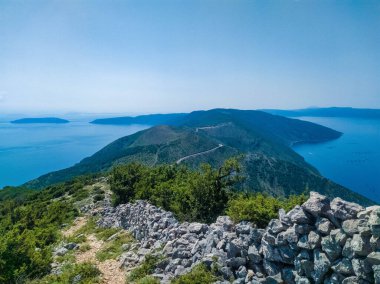 Ada Cres 'in dağlık kıyı şeridi orman ve el değmemiş deniz ile kaplı.