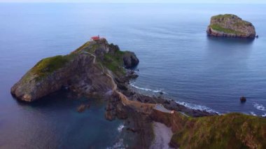 Günbatımında Aketxe adasının yanındaki San Juan de Gaztelugatxe adasının panoramik manzarası, Biscay, Bask Bölgesi 'nde Cantabrian Denizi ile yıkanır.
