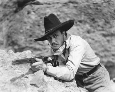 Güneşli bir günde kayaya dayanmış haydut portresi.