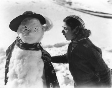 Şok olmuş genç kız tahrip edilmiş kardan adama bakıyor.