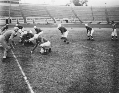 Erkek sporcular sahada Amerikan futbolu oynarken birbirleriyle yarışıyorlar.