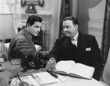 İş adamı ofiste erkek meslektaşıyla otururken plan yapıyor. 