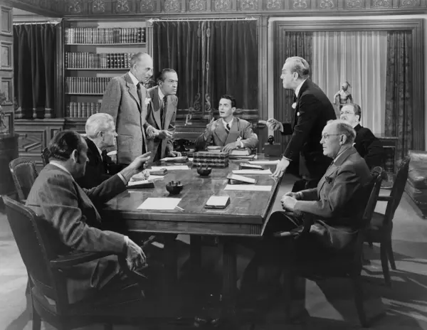 Team of male business colleagues arguing with each other during conference while sitting at table in office