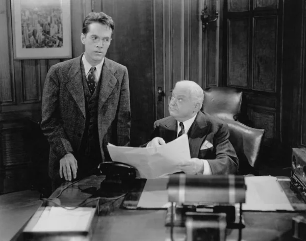 boss with documents and boss scolding personal assistant, black and white photo in the style of the 1930s.