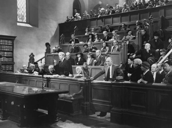Interior of courtroom with lawyers and spectators during court trial