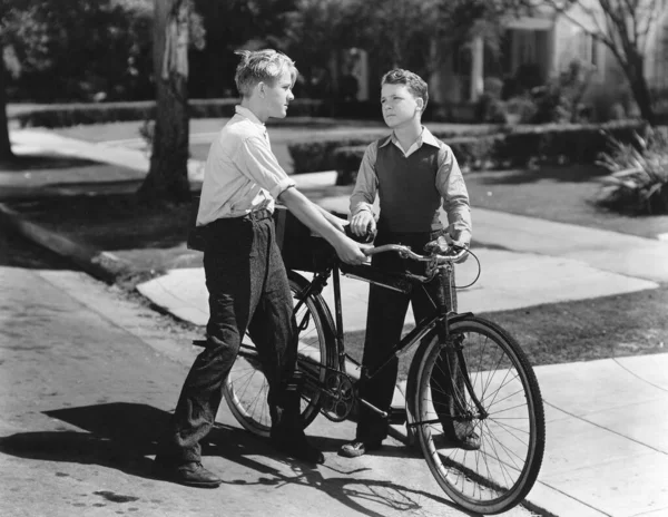 冲突期间在街上骑单车的青少年 免版税图库图片