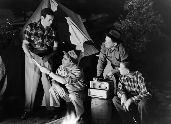 Man Showing Paper Friends Sitting Radio Tent Burning Campfire Night Stock Picture