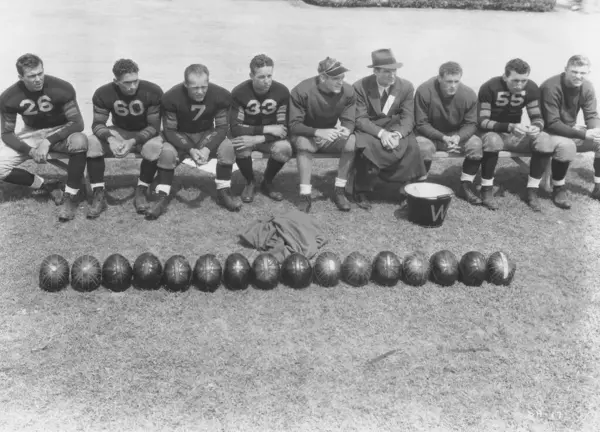 Amerykańscy Piłkarze Siedzący Trenerem Przed Piłkami Boisku Sportowym — Zdjęcie stockowe