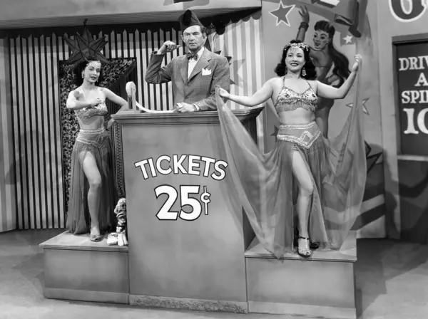チケットブース表彰台に立っているマネージャーと笑顔の女性パフォーマー ストックフォト