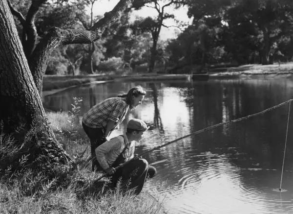 森の湖で漁をする兄弟の側面 ロイヤリティフリーのストック画像