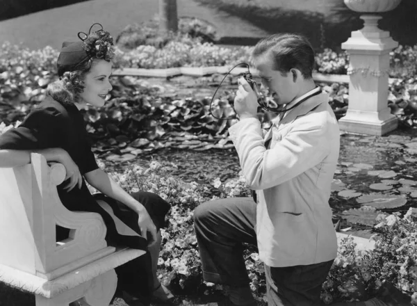 Πλευρική Άποψη Του Νεαρού Άνδρα Φωτογράφηση Φίλη Κάθεται Στον Πάγκο Royalty Free Εικόνες Αρχείου