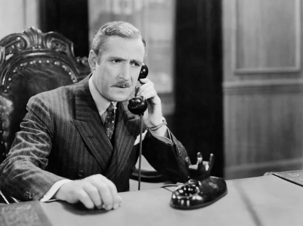 Worried Mature Man Talking Telephone While Sitting Chair Stock Picture