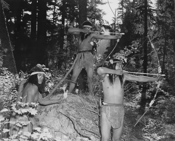 Indiani Rossi Puntano Con Archi Frecce Nella Foresta Foto Stock Royalty Free