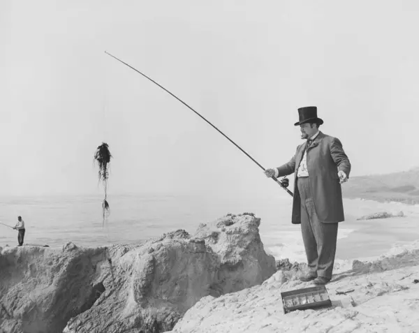 Hombre Captura Peces Con Caña Playa Día Soleado Imagen de archivo