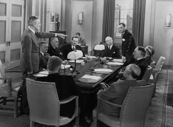 男人用手指指指在办公室开会的人 20世纪30年代风格的黑白照片 免版税图库照片