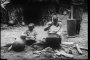 Afrikalı köylülerin örgü örüp yemek pişirme montajı