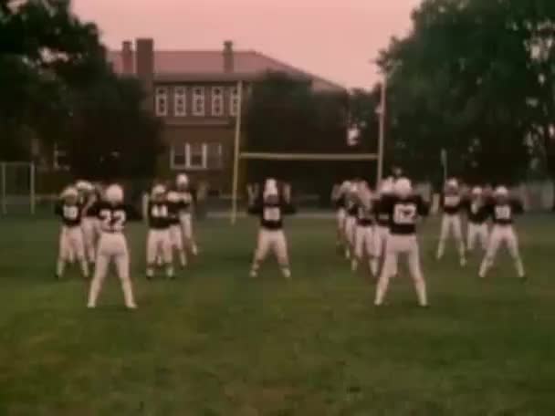 年代前的热身的高中橄榄球队 — 图库视频影像