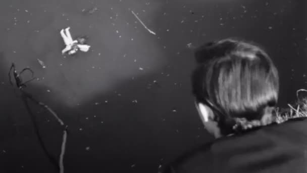 男子用棍子从河里救出玩具的后视图 — 图库视频影像