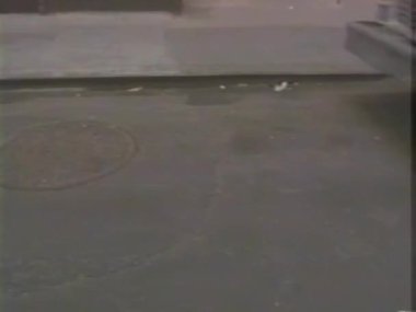 Kürk ceketli bir kadın, taksiden inerken bavullarını taşıyor.